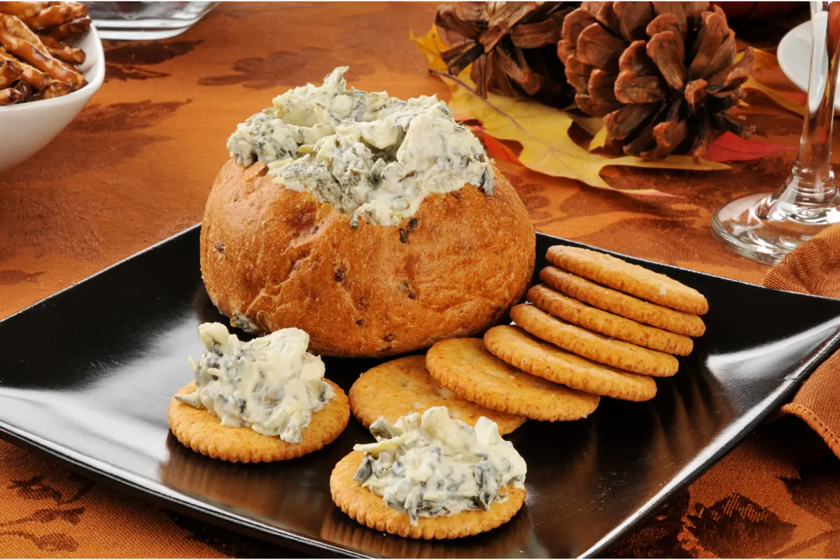 Bowl of creamy Knorr spinach dip with vegetables and crackers.