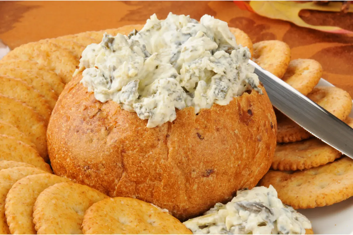 Spoon scooping creamy Knorr spinach dip, showcasing its rich texture.